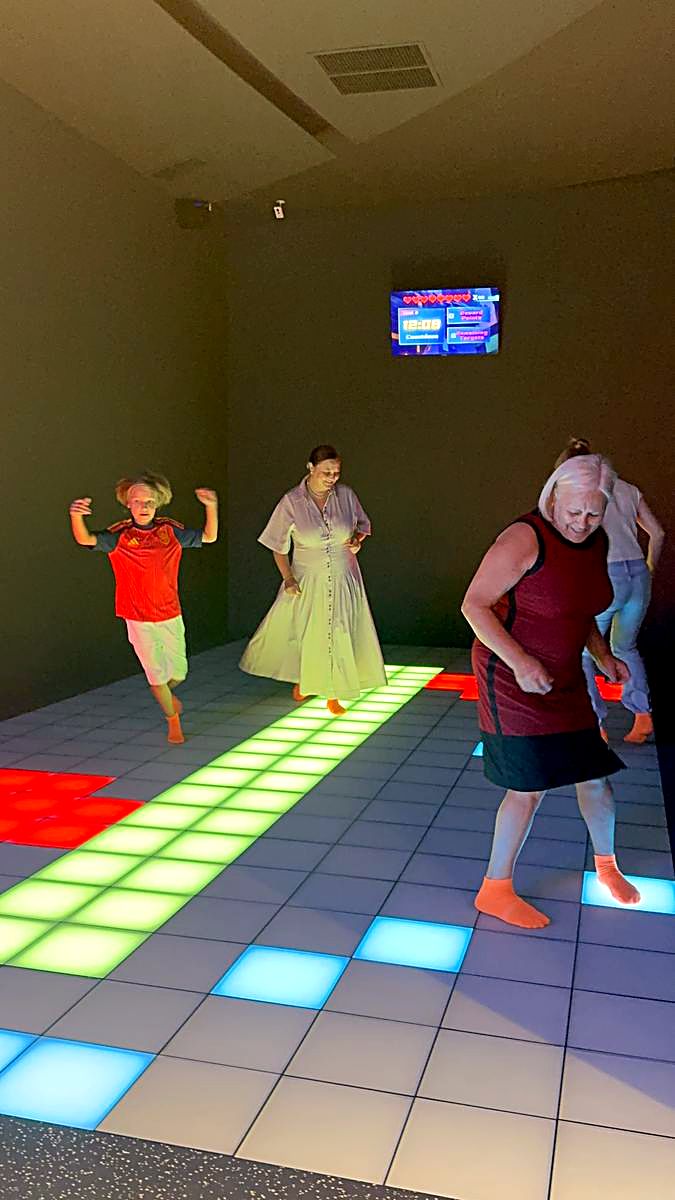 Jucător adult în șosete antiderapante portocalii pe podeaua LED interactivă