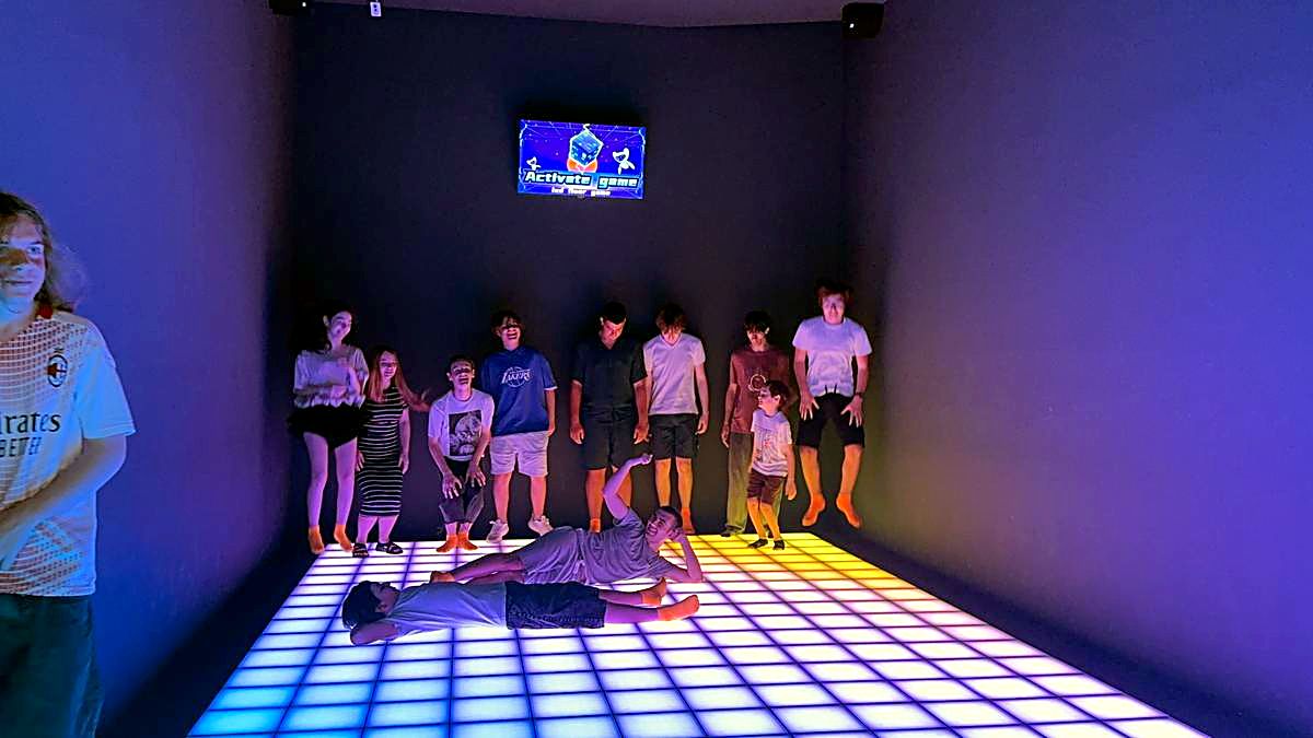 Copii jucând pe echipe pe podeaua LED albastră la o petrecere gamer în Chișinău