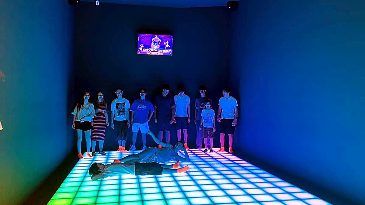Grup de copii jucând pe podeaua LED verde și galbenă la Hai Pixel din Chișinău