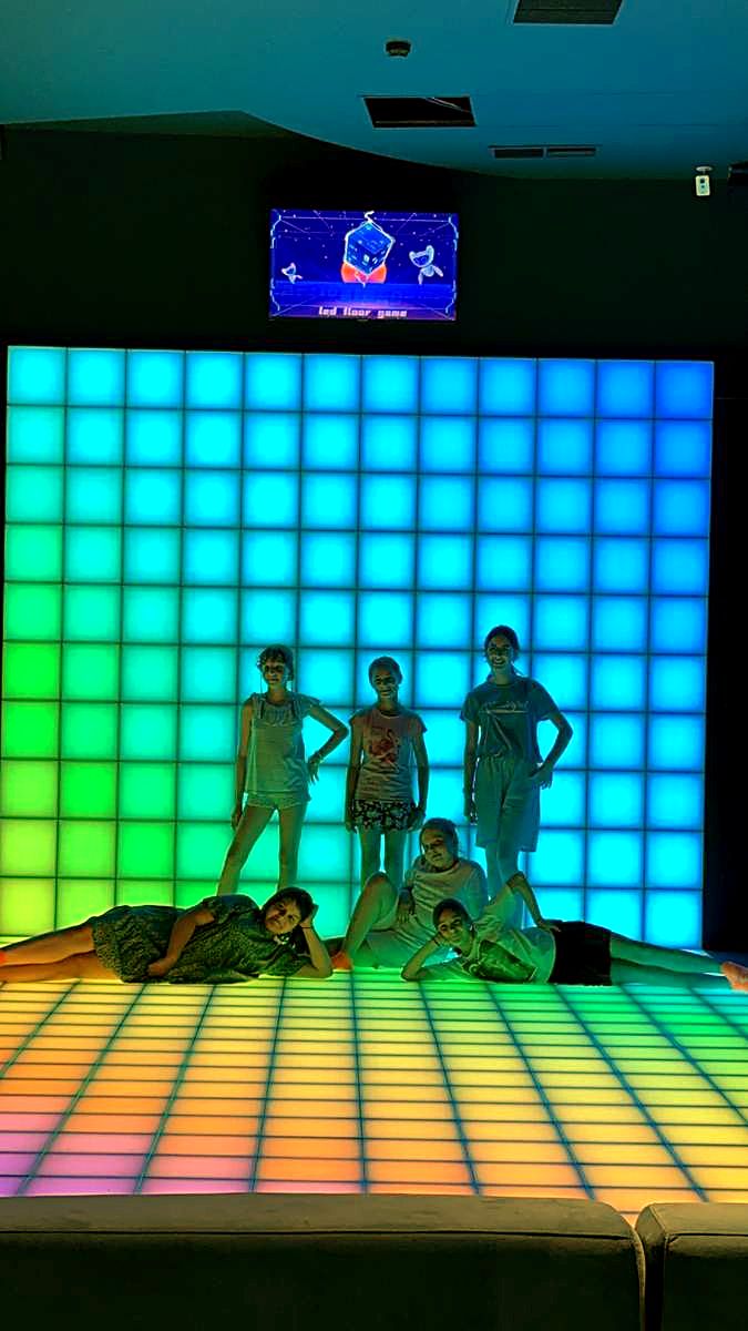 Grup în fața peretelui LED interactiv luminat în turcoaz, la Hai Pixel din Chișinău