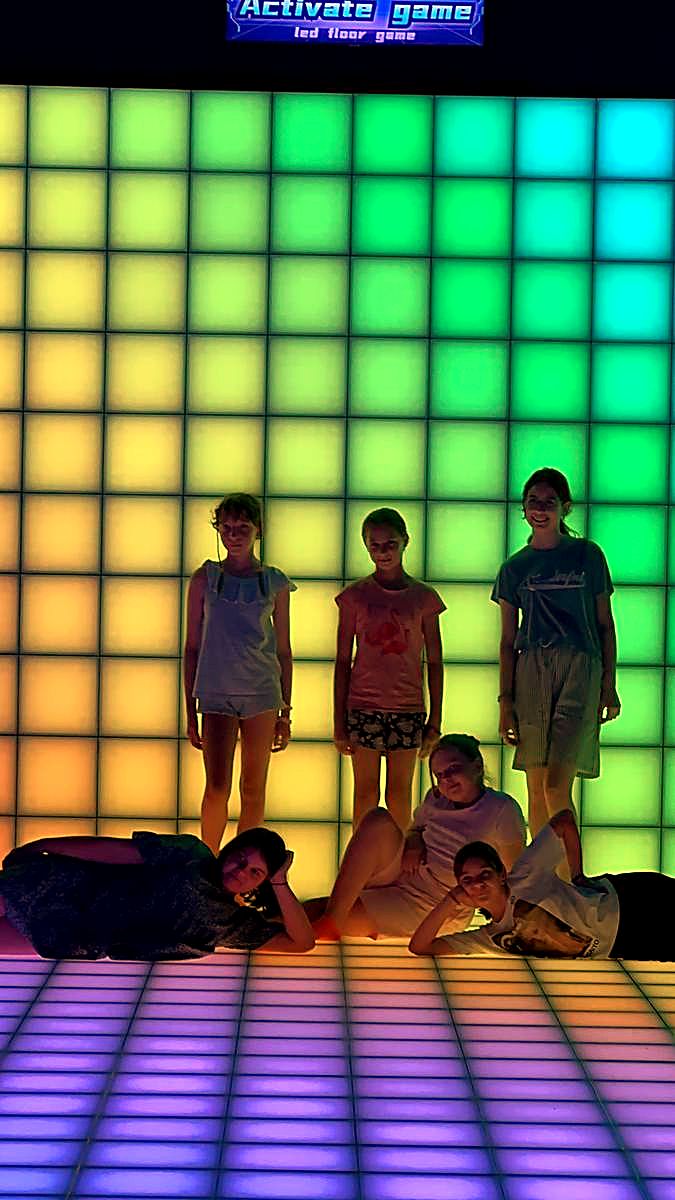 Perete LED interactiv luminat verde mentă, cu jucători în fața lui, la Hai Pixel Chișinău